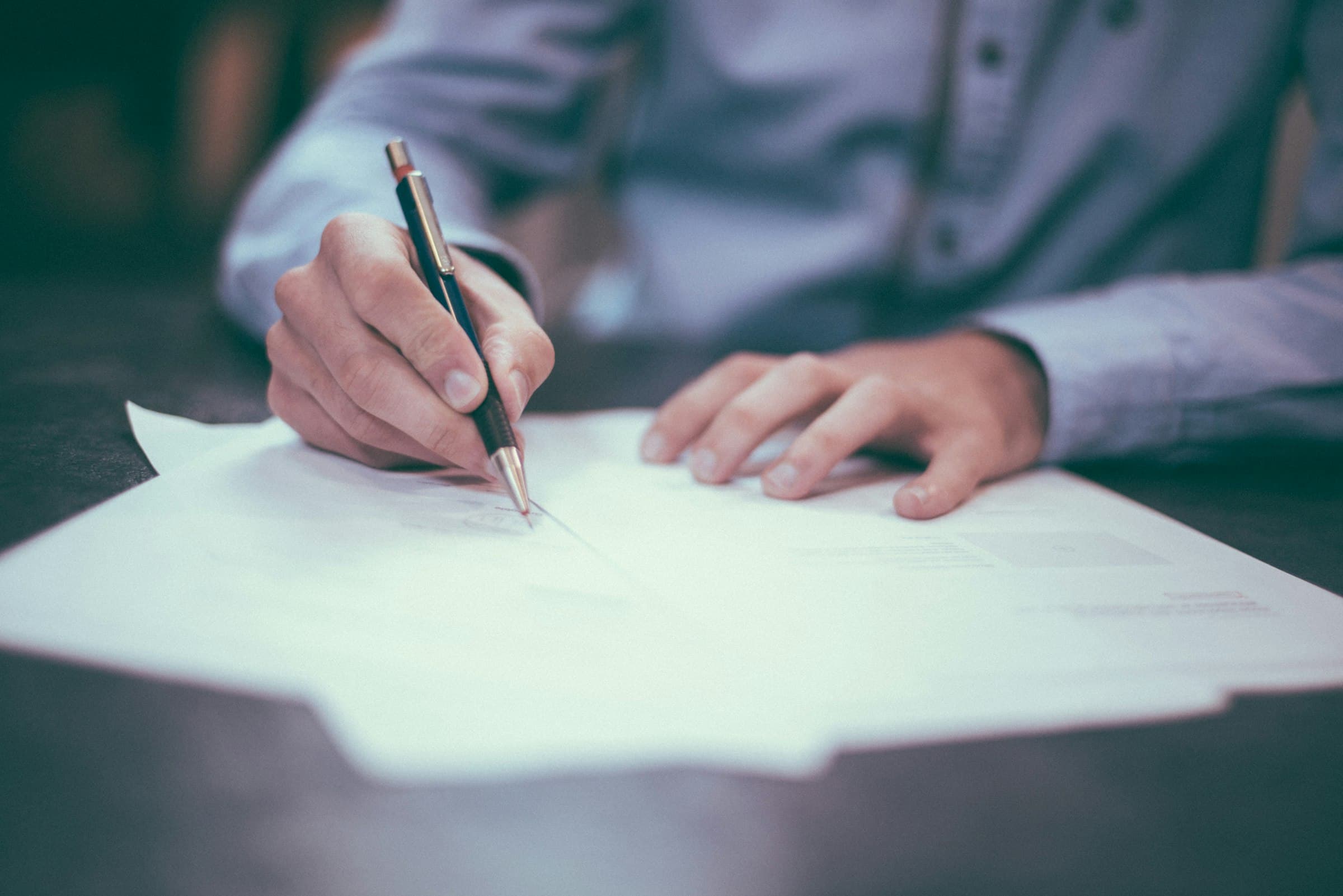 Signature d'un contrat de prestation, stylo à la main